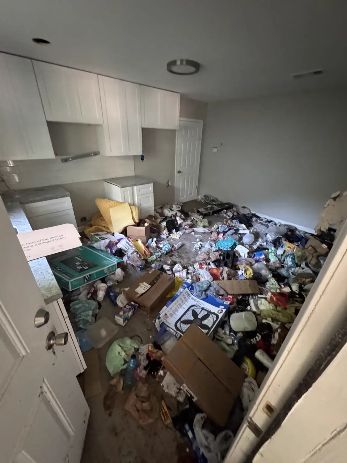 Kitchen before an Alexandria property cleanout with household debris covering the floor