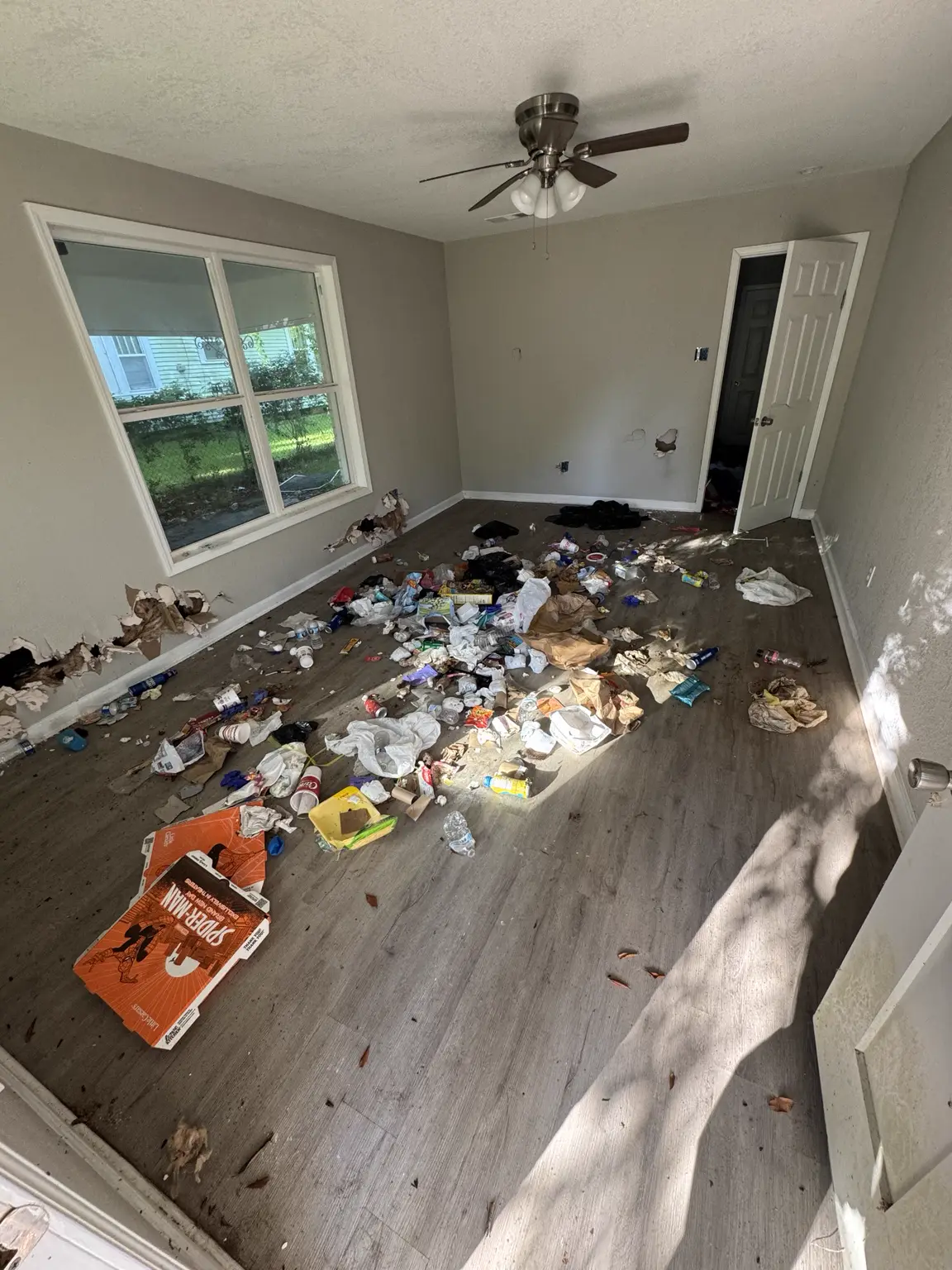 Living room before an Alexandria property cleanout with household debris on the floor